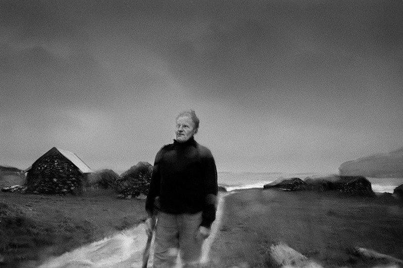 Ólavur Sörensen returns home in the rain after completing his daily chores, Húsavík, Sandoy Island, Faroe Islands, Kingdom of Denmark. 1988