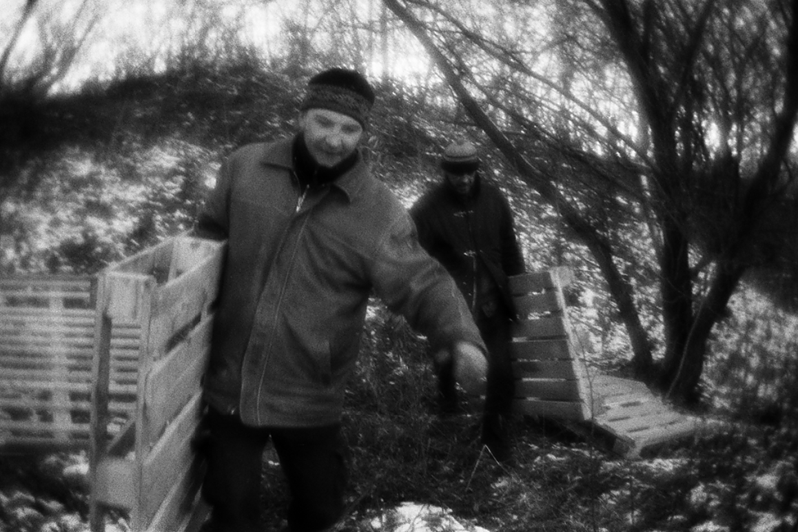 Костя и Тима переносят ранее сложенные паллеты, чтобы использовать их в качестве основания будущей "кровати", район Тропарёво-Никулино, Москва, Россия. 29 ноября 2015