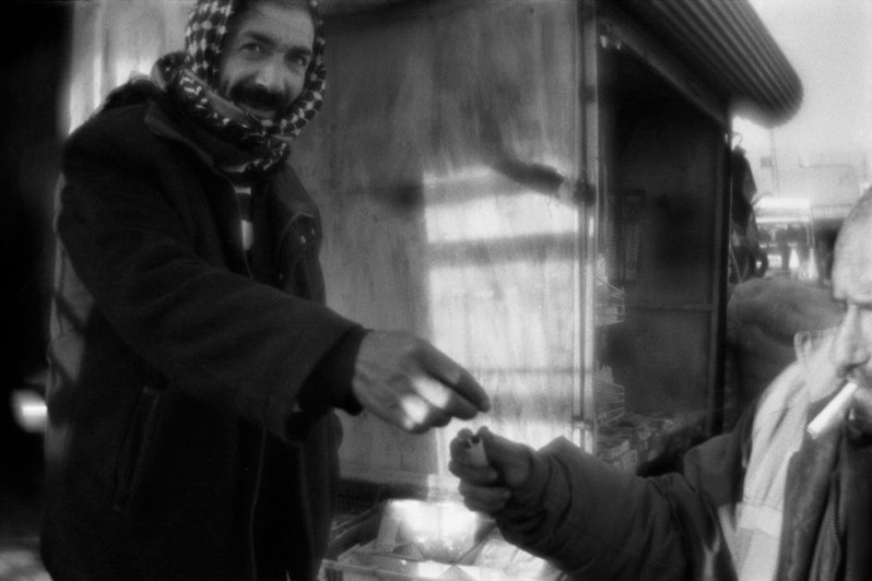 Man shares cigarets with another at the marketplace in Diyarbakır, Southeastern Anatolia region, Turkey. January 2011