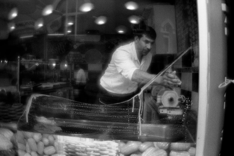 Man cleans the window of confectioner's shop, Fener district, Istanbul, Turkey. November 2012