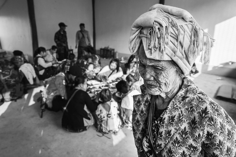 An old lady with thanaka on her face at a dining facility for guests of the Karen military parade, Kayin state, Myanmar. March 2019