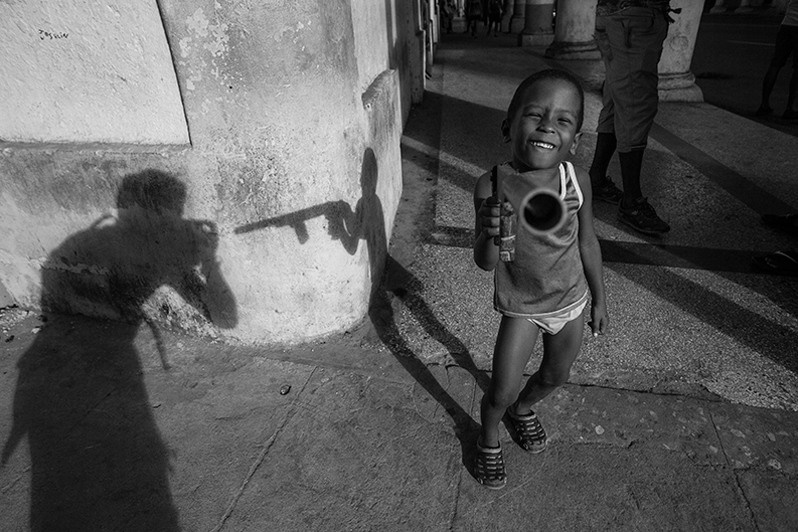 Self-portrait with a child at play on Reina street, Centro Habana district, Havana, Cuba. 2016