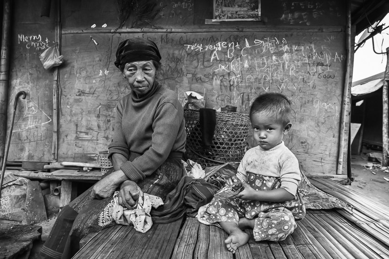Twenty months old baby boy with his grandmother eating rations of supplemenatry feeding received as humanitarian aid provided by the Kachin Baptist Convention (KBC), Hpun Lum Yang IDP camp, Kachin, Myanmar. April 2019