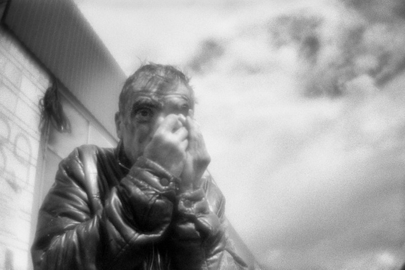 Мужчина вытирает кровь с лица после того, как поранился во время вечеринки, посёлок Мошково, Новосибирская область, Россия. Июнь 2021