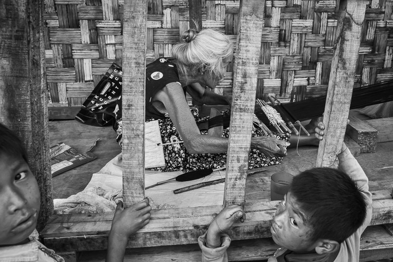 An elderly Kachin woman weaving in Hpun Lum Yang IDP camp, Kachin State, Myanmar. April 2019