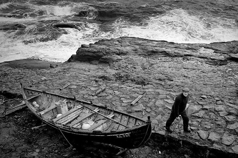 Símun Gúllaksen secures the boat ashore before the storm hits, Hattarvik village, Fugloy municipality, Faroe Islands, Kingdom of Denmark. 1988