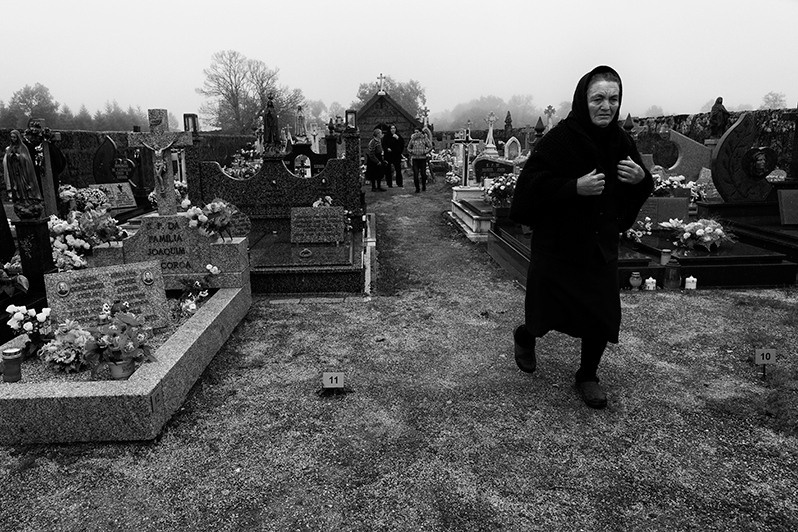 Woman leaving a cemetery after visiting the grave of her relatives, Boticas municipality, Vila Real district, Trás-os-Montes region, Portugal. 2015