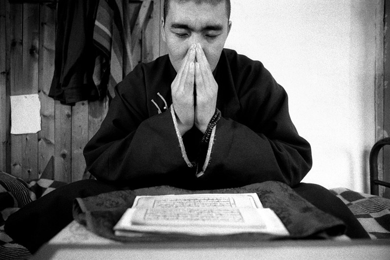 Buddhist monk of Buryat ethnicity learns by heart passages from a sacred Mongolian book, Verkhnyaya Ivolga village, Buryatia, Russia. November 2001