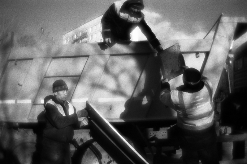 Уборщики убирают строительный мусор в грузовик, район Тропарёво-Никулино, Москва, Россия. 8 декабря 2015