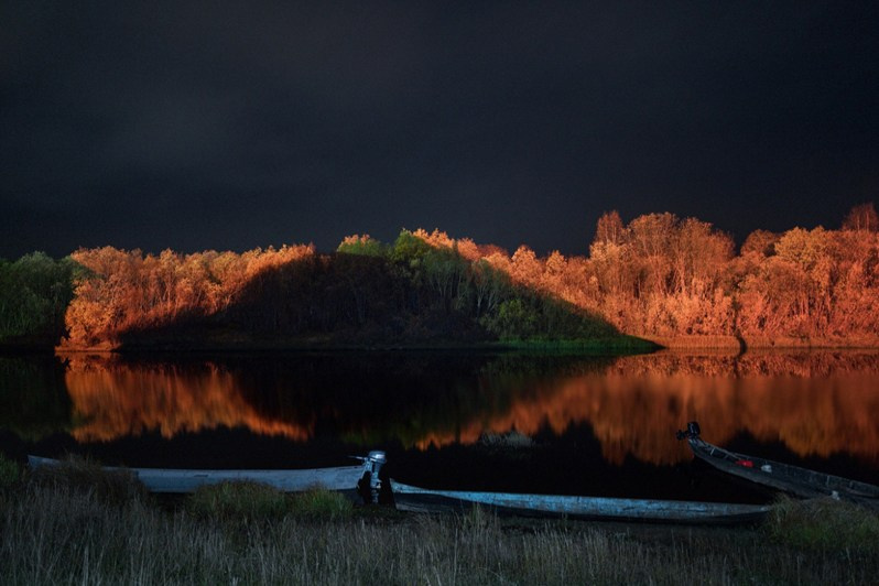 Boats at night on the banks of Kimzha, one of the smaller rivers flowing into Mezen River, Kimzha village, Mezensky district, Arkhangelsk region, Russia. 2021