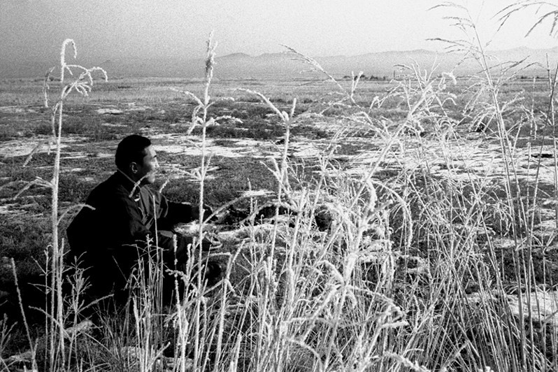 Buddhist student meditating outside the Ivolginsky datsan complex, near Verkhnyaya Ivolga village, Buryatia, Russia. November 2001