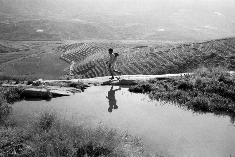 Children reflecting on the valley of terraced rice paddies, near Ambalavao, Haute Matsiatra region, Fianarantsoa province, Republic of Madagascar. 2012