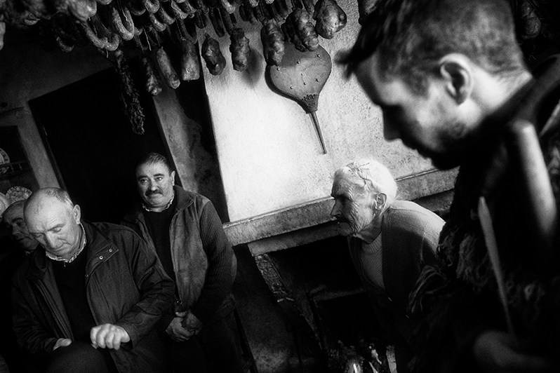 Under the watchful eye of “Careto” and the inhabitants of the house, the singers pray for the soul of a person who lived here, Bragança municipality, Bragança district, Trás-os-Montes region, Portugal. 2019