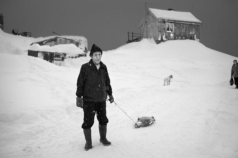 Seal hunter with catch of the day, Tiniteqilaaq settlement, Sermersooq municipality, Greenland, Kingdom of Denmark. 2015