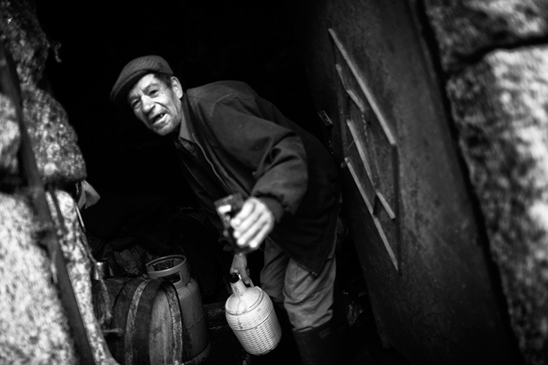 Man offering a glass of homemade wine, Montalegre municipality, Vila Real district, Trás-os-Montes region, Portugal. 2016