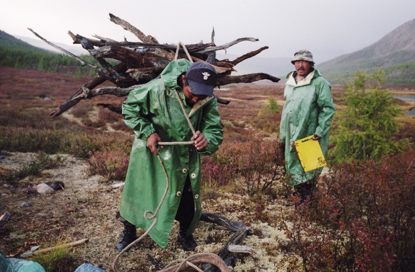 Preparing wood for the evening campfire and meal, Ulaan Taiga mountains, Khövsgöl province, Mongolia. September 2009