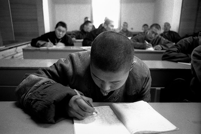 Young Buddhist monk is learning English after basic lessons, Verkhnyaya Ivolga village, Buryatia, Russia. November 2001