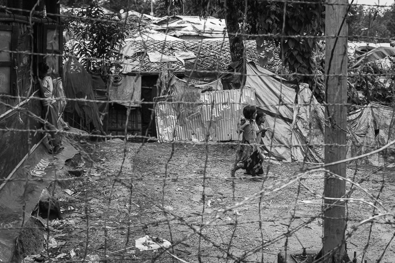 Fences, barbed wire and watch towers are surrounding the refugee camps making it very hard to reach clinics, stores and commodities located outside the camps, Kutupalong refugee camp, Cox's Bazar, Bangladesh. September 2022
