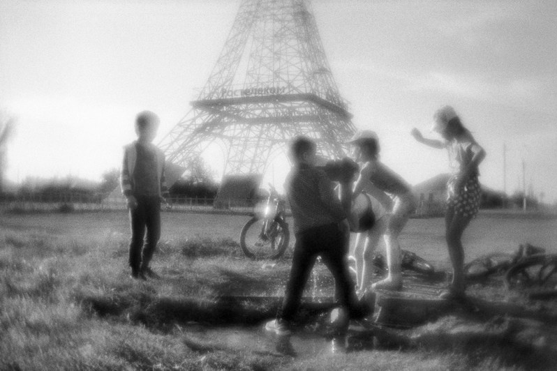 Дети играют возле водокачки перед вышкой сотовой связи в форме Эйфелевой башни, посёлок Париж, Нагайбакский район, Челябинская область, Россия. Июль 2022