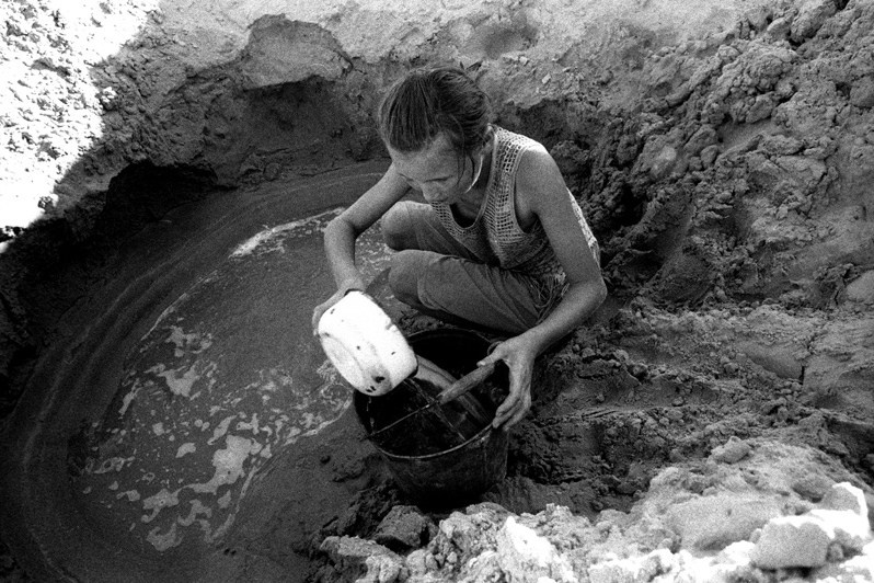 Kazakh woman collecting water in a well, Bogen village, Aralsk district, Kyzyl-Orda region, Kazakhstan. August 2001