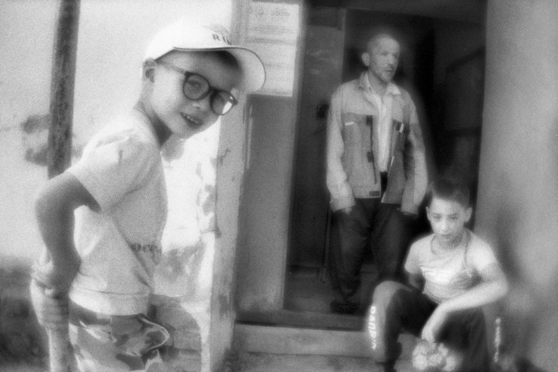 Слегка пьяный дедушка играет в футбол со своим внуком, используя вход в дом в качестве ворот, посёлок Вурнары, Чувашская Республика, Россия. Сентябрь 2020