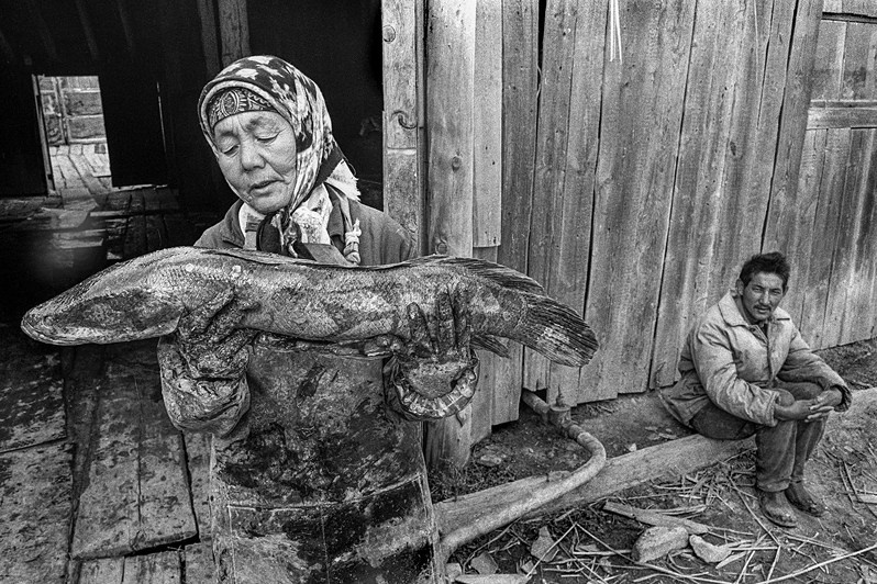 A woman with a fish caught in the waters of the former Aral Sea, near Muynak, the Republic of Karakalpakstan, Uzbekistan. September 1992 © Oleg Klimov