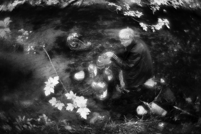 Саша набирает воду для "технических нужд" в реке, протекающей в овраге, район Тропарёво-Никулино, Москва, Россия. 9 мая 2015