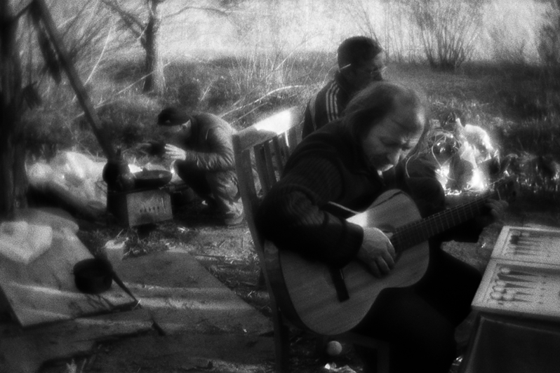 У Володи всегда есть гитара. Гитары быстро портятся от плохих условий жизни. Люди здесь едят из одной посуды, район Тропарёво-Никулино, Москва, Россия. 6 мая 2015