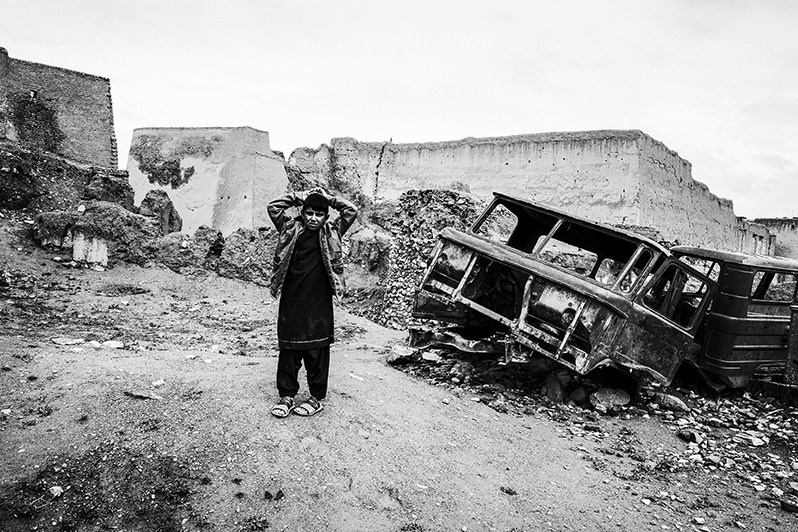 Afghan teenager against the background of broken Soviet equipment left in the citadel of Ghazni, Ghazni, Afghanistan. 2024