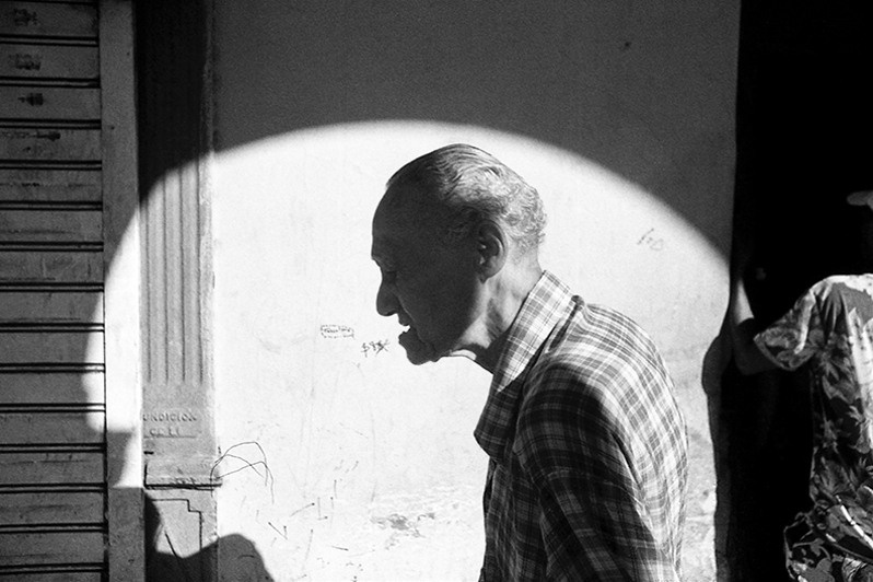 Portrait of an elderly man walking along Rhein street, Centro Habana district, Havana, Cuba. 2022