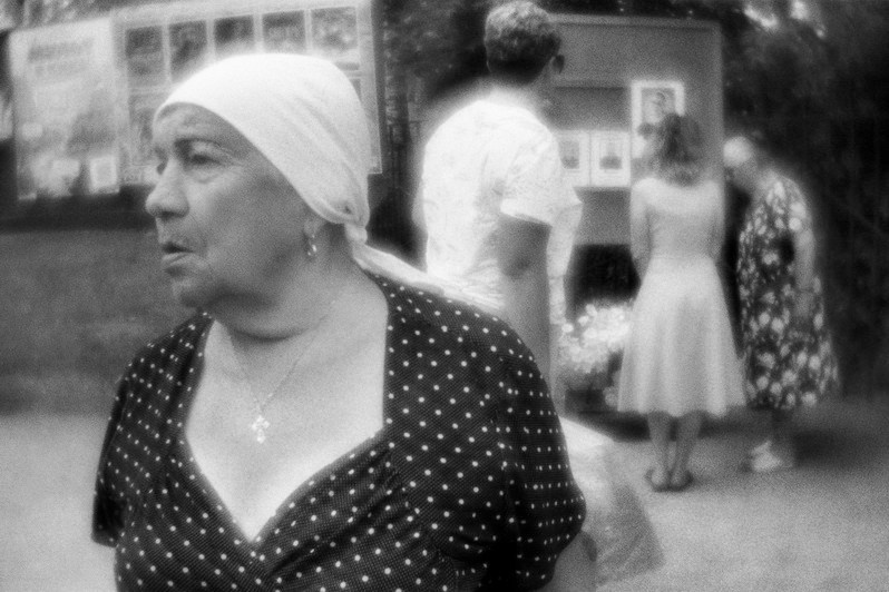 Люди обсуждают страшную новость о зверском убийстве 12-летней девочки, совершенном 2 дня назад, у её портрета на памятном стенде, Сим, Ашинский район, Челябинская область, Россия. Июль 2023