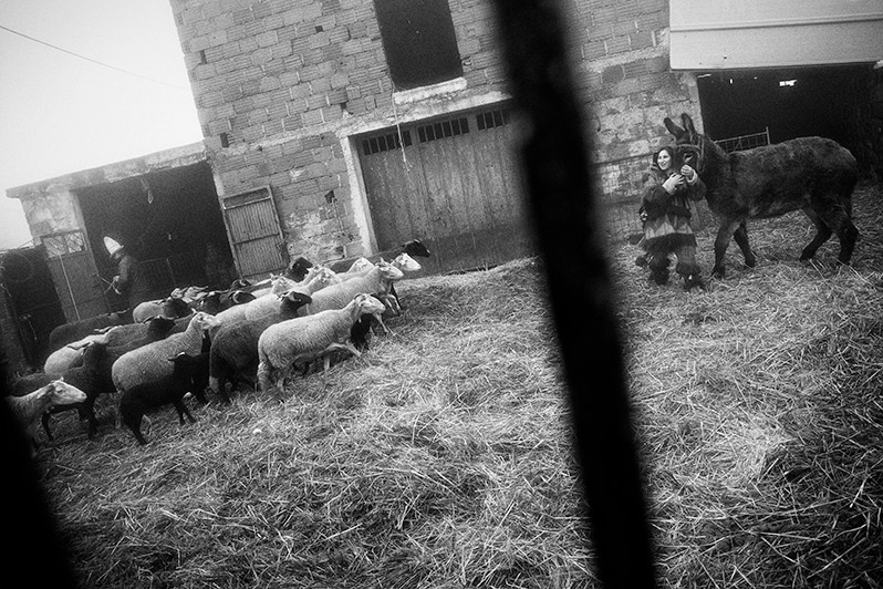 The “Bispo” and his wife masked as “Careto” take care of their flock during the “Ronda”, Bragança municipality, Bragança district, Trás-os-Montes region, Portugal. 2019