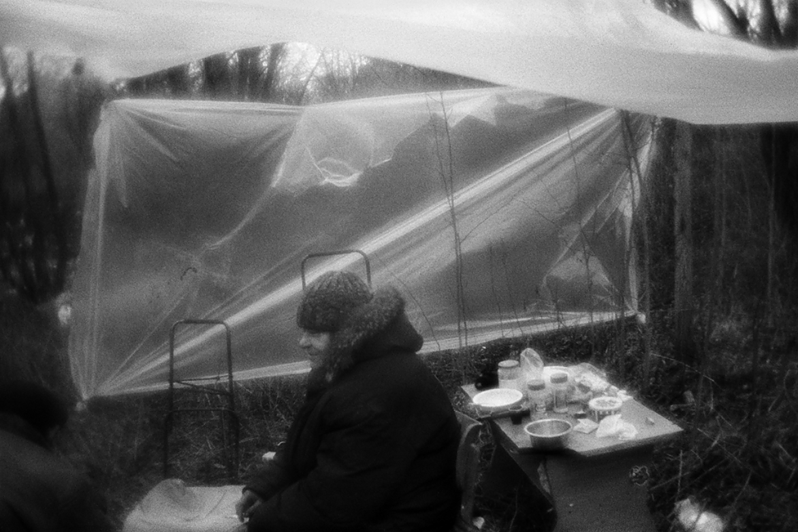 Валя прячется за импровизированной стеной из целлофана, пытаясь защититься от ветра, район Тропарёво-Никулино, Москва, Россия. 24 декабря 2015