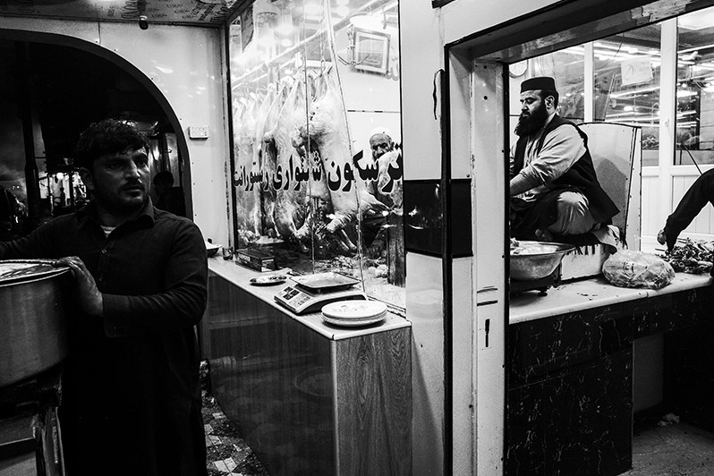 Whatever the weather, the butcher cuts the desired cut of meat and cooks it on a large street grill, Shur Bazar, Kabul, Afghanistan. 2024