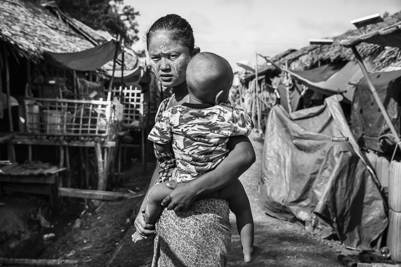 Mother and child displaced from nearby villages that are on the frontline where regular combat occures, Thein Nyo IDP camp, Rakhine State, Myanmar. October 2019