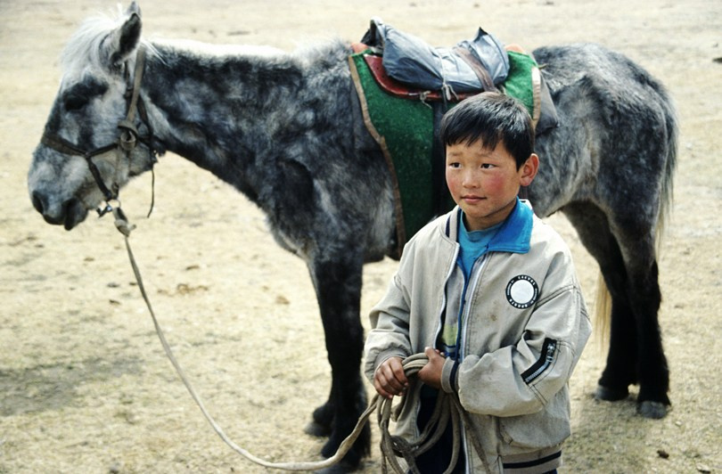 Portrait of boy and his little horse, Ömnögovi province, Mongolia. April 2005