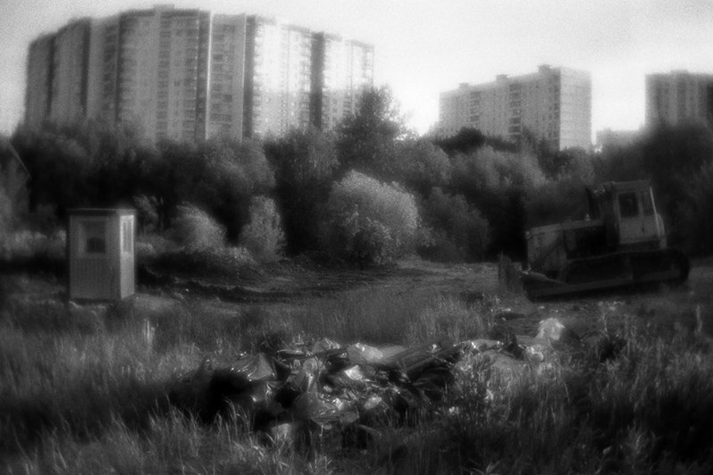 В июне бульдозер начал разравнивать землю под будущее строительство в овраге. На переднем плане — мусор от снесённой палатки Тимы и Наташи, район Тропарёво-Никулино, Москва, Россия. 1 июня 2015