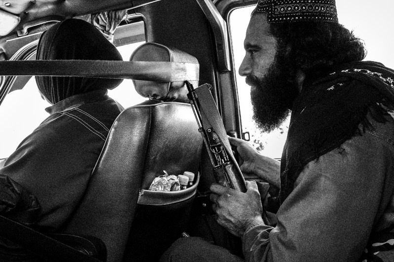 Talib guard from Ministry of Culture escorting foreign tourists, Balkh, Afghanistan. 2024