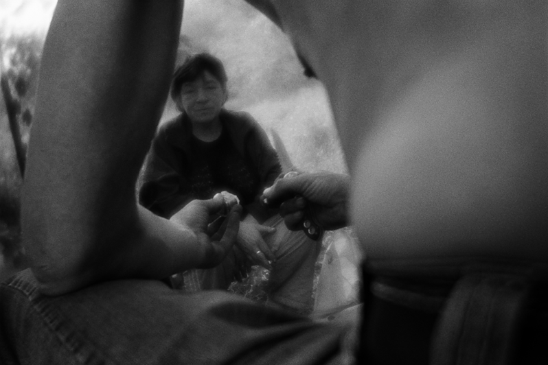 Валя смотрит, как Костя разбирает трансформатор, извлекая из него медь, район Тропарёво-Никулино, Москва, Россия. 26 мая 2015