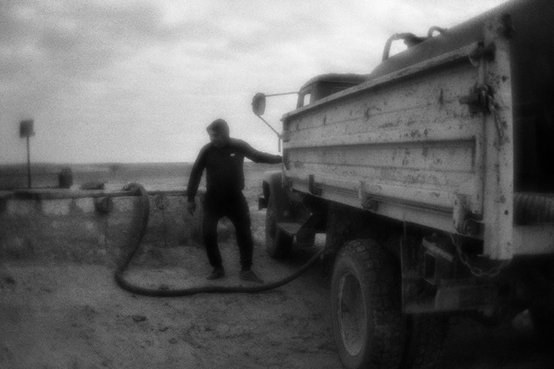 Водовоз забирает воду из колодца, чтобы раздать её местным жителям, посёлок Эрдниевский, Юстинский район, Республика Калмыкия, Россия. Сентябрь 2017