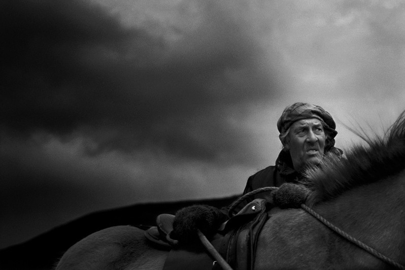 Guðmann Magnússon, one of the farmers at Vindhæli in Skagaströnd, stars at the storm clouds, stone-faced, Vindhæli farm, near Skagaströnd village, Norðurland Vestra region, Iceland. 1991