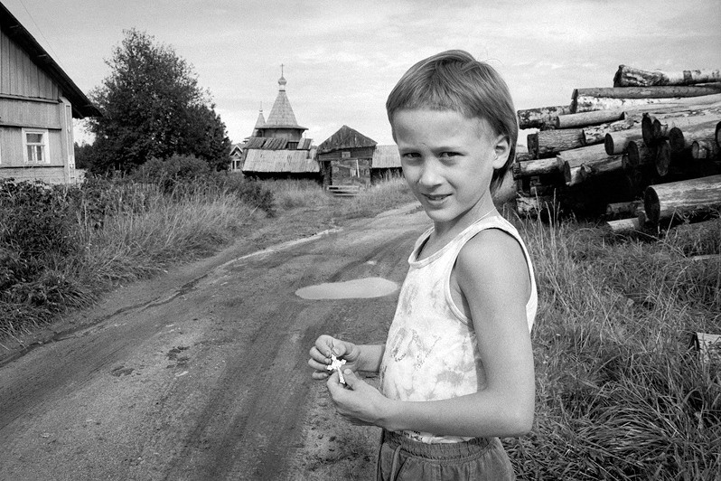 Портрет мальчика с нательным крестиком, который он нашёл на обочине дороги, деревня Погост, Пудожский район, Карелия, Россия. Август 2007