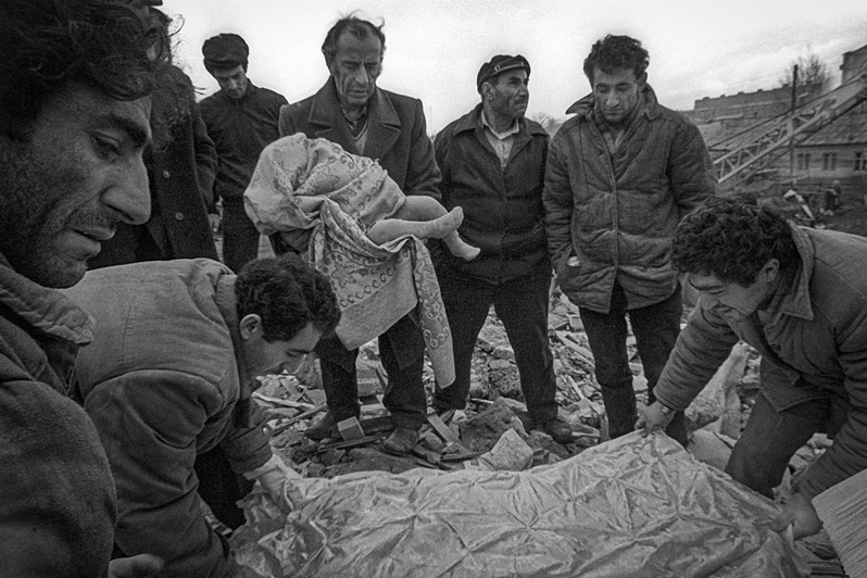 Men holding the body of a child found in the ruins of a building during the Spitak earthquake, Leninakan, Armenian SSR, USSR. December 1988 © Oleg Klimov