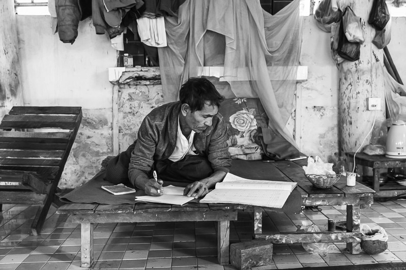 Arkanese internally displaced person updating the list of persons residing in a temporary shelter, Parabo pagoda, Mrauk-Oo, Rakhine state, Myanmar. February 2020