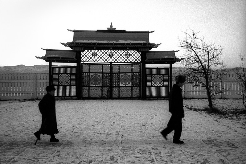 The day is coming to an end and the last of the indigenous Buryats, having finished the spinning of the prayer drums, go home, Verkhnyaya Ivolga village, Buryatia, Russia. November 2001
