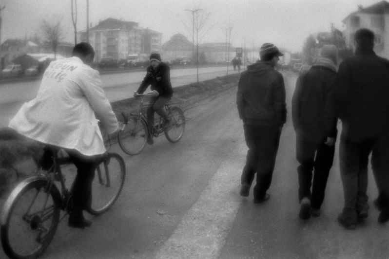 Сyclists and teenagers near the road in Düzce town, Turkey. January 2008