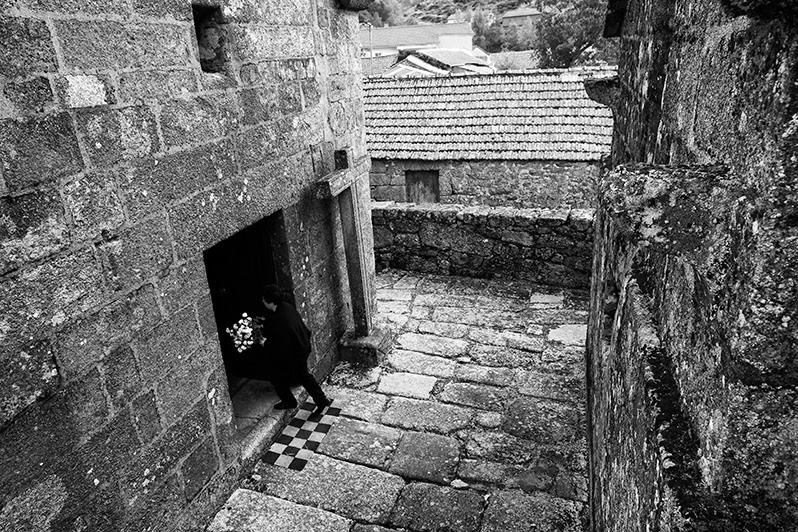Woman brings flowers to a village person who died, Montalegre municipality, Vila Real district, Trás-os-Montes region, Portugal. 2016