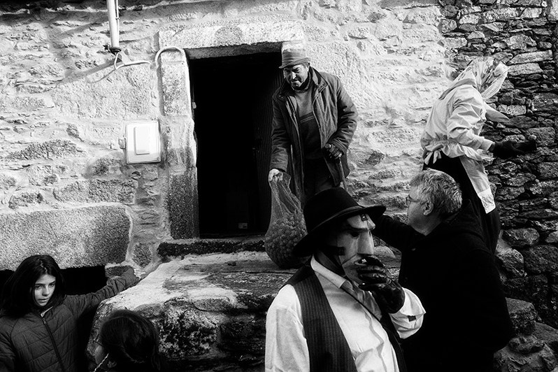 Villager offers nuts to “Mascarinha” during “Peditório”, Mogadouro municipality, Bragança district, Trás-os-Montes region, Portugal. 2020