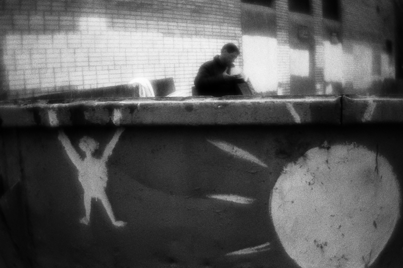 Костя проверяет мусорный контейнер, пытаясь найти что-нибудь полезное по пути к контейнеру для помоев продуктового магазина, район Тропарёво-Никулино, Москва, Россия. 8 мая 2015