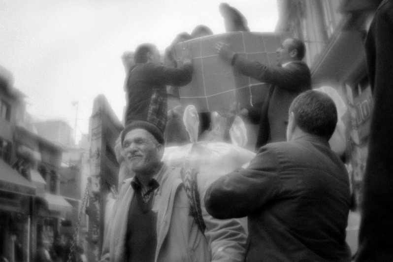 People help to the loader to unload at the market, Istanbul, Turkey. January 2011